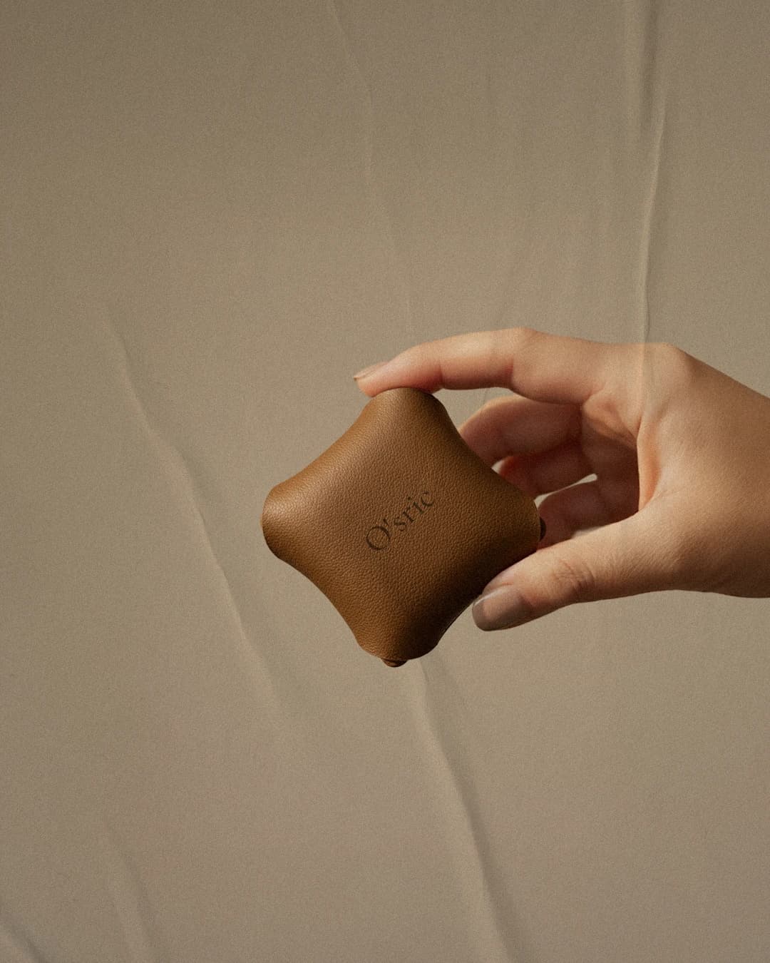 O'sric leather car diffuser held in a hand