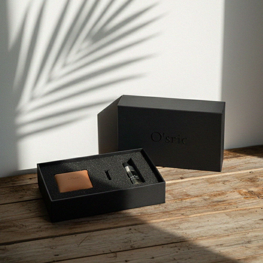 Black car diffuser gift box with 'O'sric' branding on a wooden surface with a white wall background.